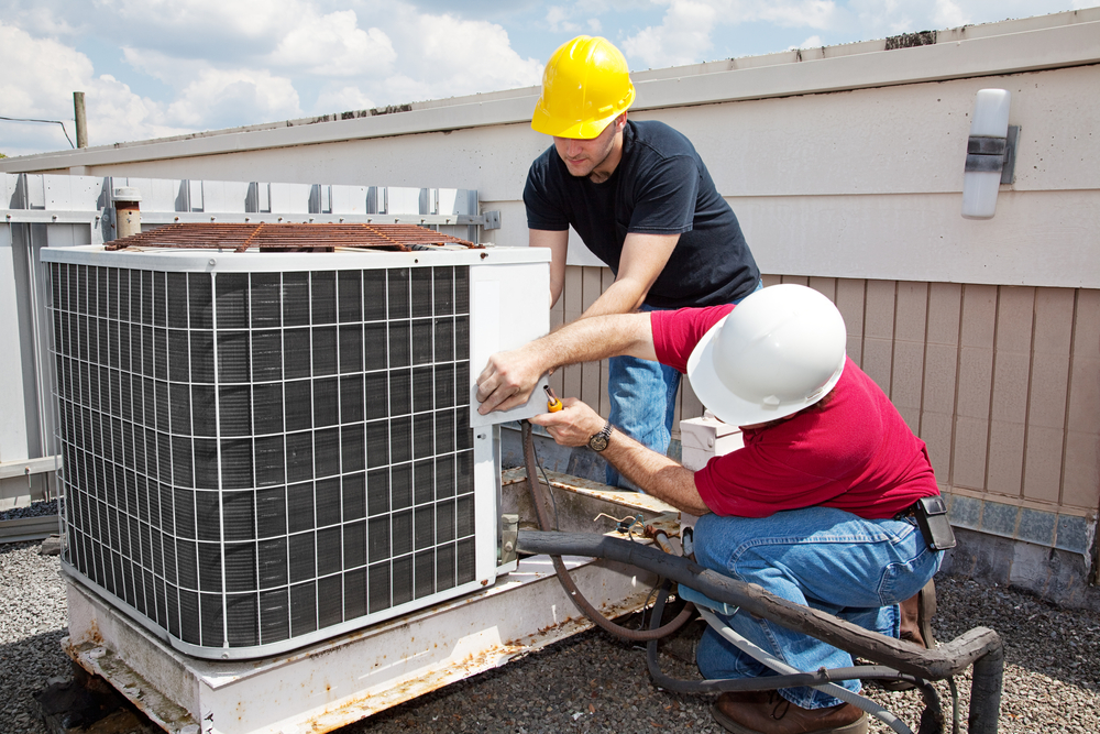 Technicians installing an air conditioning unit.