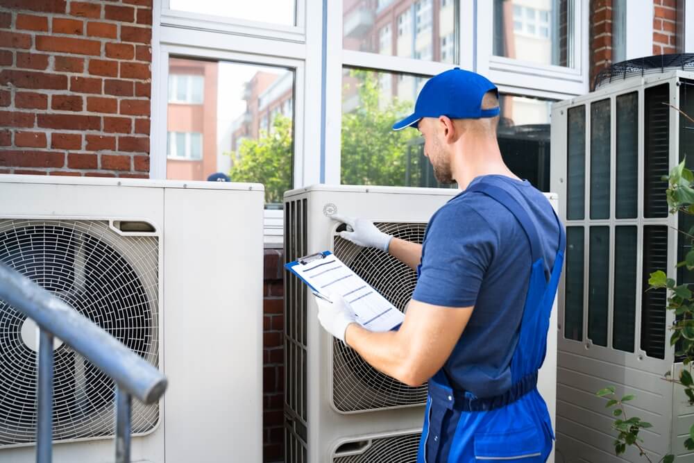 HVAC technician inspects outdoor unit