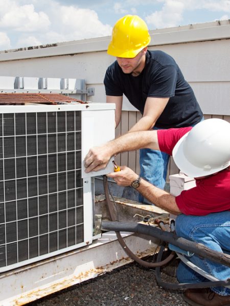 Technicians installing an air conditioning unit.